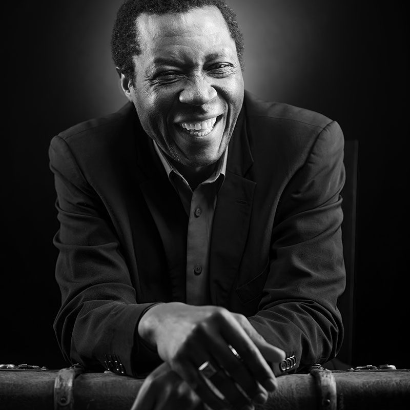 A man in suit and tie smiling for the camera.