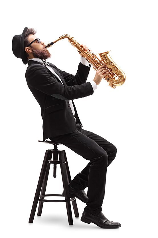 A man sitting on top of a stool playing the saxophone.