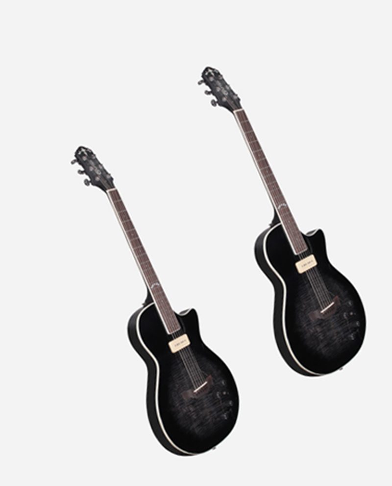 Two black guitars are standing up against a white wall.