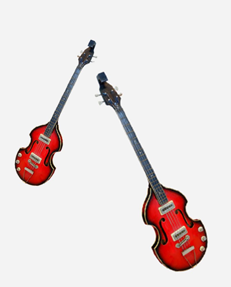 Two red guitars are standing up against a white wall.
