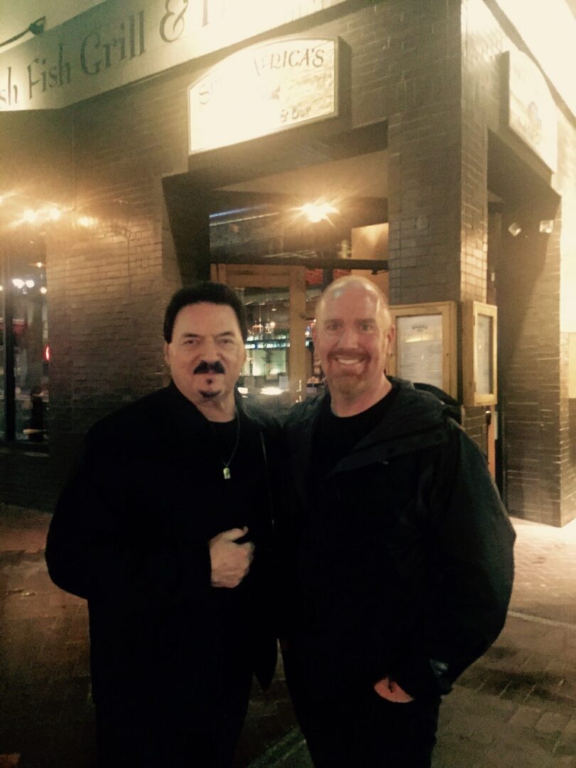 Two men standing in front of a building.