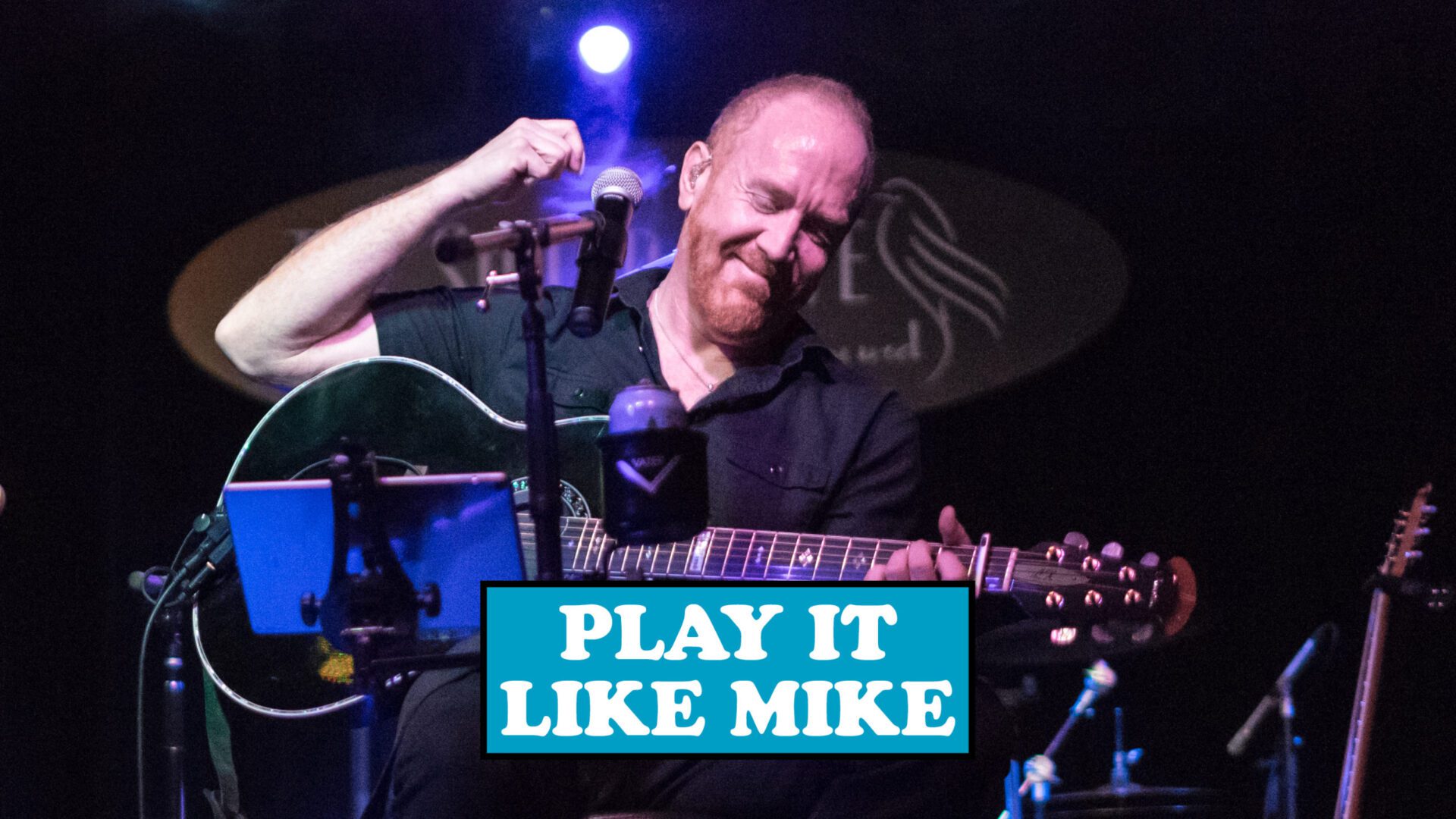 A man playing guitar with the words " play it like mike ".