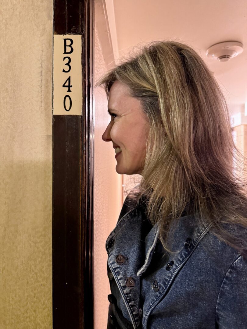 A woman smiling next to a wall with 'B340' sign.
